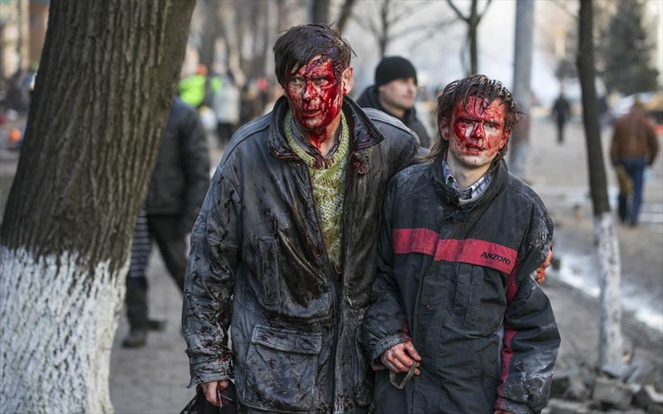 Ουκρανία - Κίεβο - Διαδηλώσεις. Δύο άντρες που τραυματίστηκαν κατά τη διάρκεια συγκρούσεων με την αστυνομία περπατούν στο κέντρο του Κιέβου. 