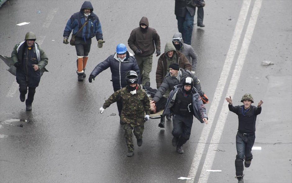 Ουκρανία - τραυματίες. Αντικυβερνητικοί διαδηλωτές μεταφέρουν τρέχοντας ένα τραυματία στην πλατεία Ανεξαρτησίας στο Κίεβο.