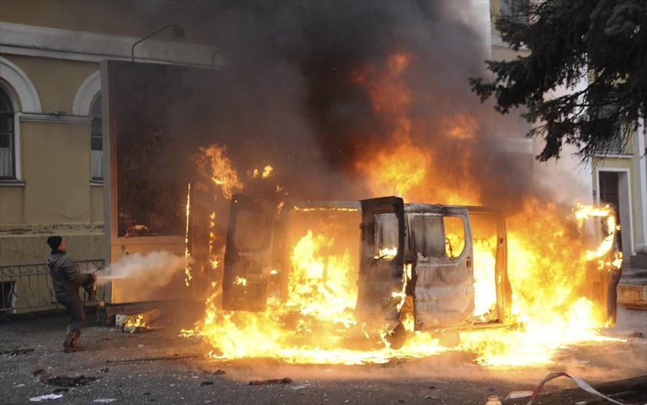 Ουκρανία - Κίεβο - επεισόδια. Ένας άνδρας επιχειρεί να σβήσει την φωτιά που έχει προκληθεί σ’ ένα όχημα στο κέντρο του Κιέβου.