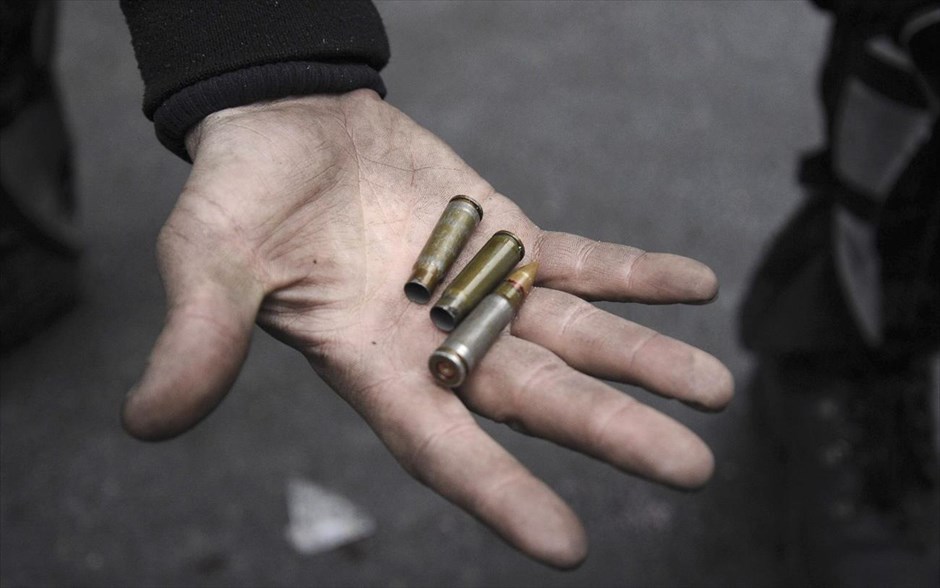 Ουκρανία - Κίεβο - σφαίρες. Ένας άνδρας κρατά στο χέρι του μία σφαίρα και άδειους κάλυκες.