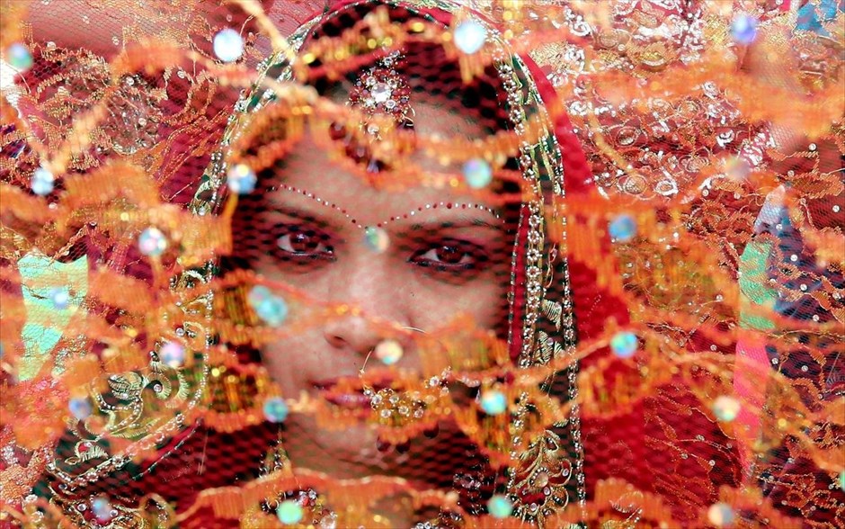 Ινδία: Ομαδικοί γάμοι στη Μποπάλ. Μία γυναίκα συμμετέχει σε τελετή ομαδικών γάμων στη Μποπάλ της Ινδίας. Περίπου 45 ζευγάρια παντρεύτηκαν σε τελετή ομαδικών γάμων που διοργανώθηκε για τα μη προνομιούχα ζευγάρια στην περιοχή.