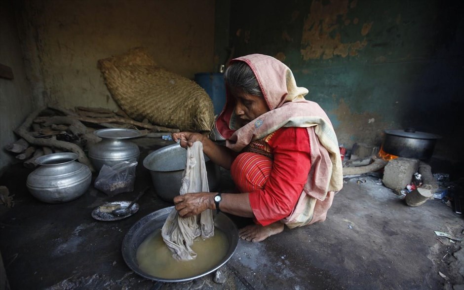 Ημέρα της Γυναίκας - Γυναίκες από όλο τον κόσμο - Πακιστάν. Η 55χρονη Καντίτζα πλένει τα ρούχα της σε μία αυτοσχέδια καλύβα όπου πουλά τσάι, στα περίχωρα του Καράτσι, στο Πακιστάν. Η Καντίτζα ετοιμάζει τσάι καθόλη την ημέρα και πουλά το ένα φλιτζάνι τσάι για 10 Πακιστανικές ρουπίες ($ 0,09) και κερδίζει περίπου 1200 Πακιστανικές ρουπίες ($ 12) την ημέρα.