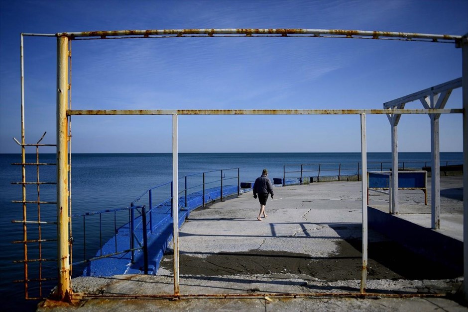 Περίπατος σε παραθαλάσσιο θέρετρο της Κριμαίας . Ένας άντρας περπατά πάνω σε παραλιακό δρόμο του παραθαλάσσιου θερέτρου Αλούστα, στη νότια ακτή της χερσονήσου της Κριμαίας. Ο ρώσος πρόεδρος Βλαντιμίρ Πούτιν υπέγραψε την Τρίτη μια ιστορική συνθήκη που συνδέει την Κριμαία στη Ρωσία, με άμεση ισχύ, αγνοώντας τις δυτικές κυρώσεις που έχουν επιβληθεί εναντίον της Μόσχας.