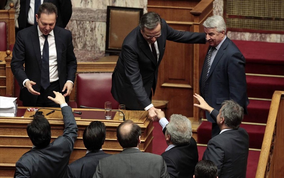 «Ναι» στο πολυνομοσχέδιο. Βουλευτές της συμπολίτευσης συγχαίρουν τον πρωθυπουργό Αντώνη Σαμαρά και τα μέλη της κυβέρνησης ύστερα από την ολοκλήρωση της ψηφοφορίας για το πολυνομοσχέδιο. Η καταψήφιση του Γιώργου Παπανδρέου στο άρθρο 2 για τις τράπεζες σημάδεψε την ονομαστική ψηφοφορία που προκάλεσε ο ΣΥΡΙΖΑ με την οποία εγκρίθηκε το πολυνομοσχέδιο.