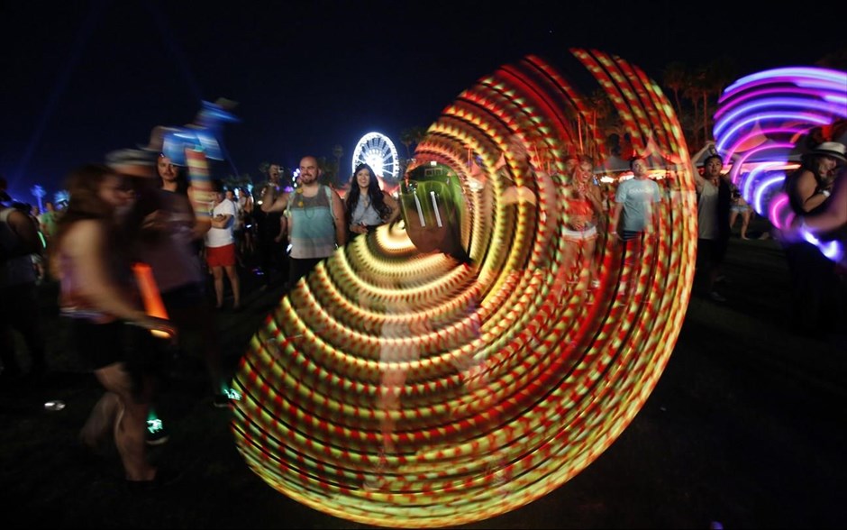 Παιχνίδι με το φως στο φεστιβάλ Coachella. Ένας άνδρας παίζει με φωτεινό χούλα χουπ, ενώ βρίσκεται σε εξέλιξη συναυλία του διδύμου από τον Καναδά Chromeo, στο πλαίσιο του μουσικού φεστιβάλ Coachella που πραγματοποιείται στην Καλιφόρνια των ΗΠΑ. 