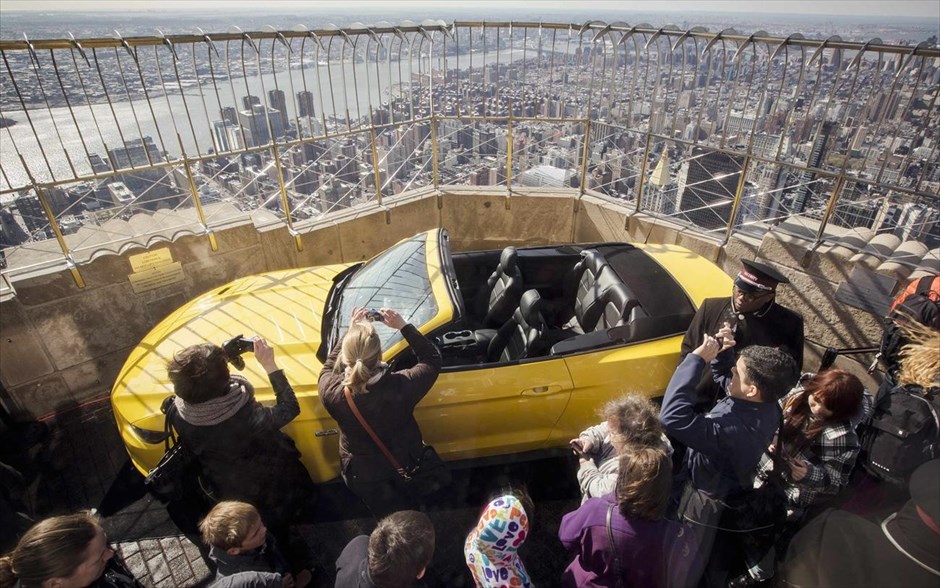 Tο νέο μοντέλο Ford Mustang στην ταράτσα του Empire State Building. Τουρίστες φωτογραφίζουν το νέο μοντέλο Ford Mustang GT 2015 που εκτίθεται στον 86ο όροφο του Empire State Building της Νέας Υόρκης. Το γεγονός συμπίπτει με την ετήσια έκθεση αυτοκινήτου της Νέας Υόρκης. Ιδιαίτερα ενδιαφέρον είναι ο τρόπος μεταφοράς του οχήματος, το οποίο κόπηκε σε κομμάτια για να μεταφερθεί με το μικρό ασανσέρ του κτιρίου.
