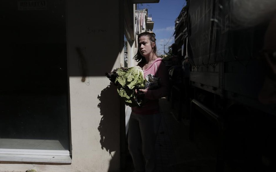 Διανομή τροφίμων από παραγωγούς λαϊκών αγορών. Ένα κορίτσι κρατάει μια σακούλα με λαχανικά κατά τη διάρκεια δωρεάν διανομής αγροτικών προϊόντων από παραγωγούς, στο πλαίσιο των κινητοποιήσεών τους, στη λαϊκή αγορά του Κολωνού, στην Αθήνα.