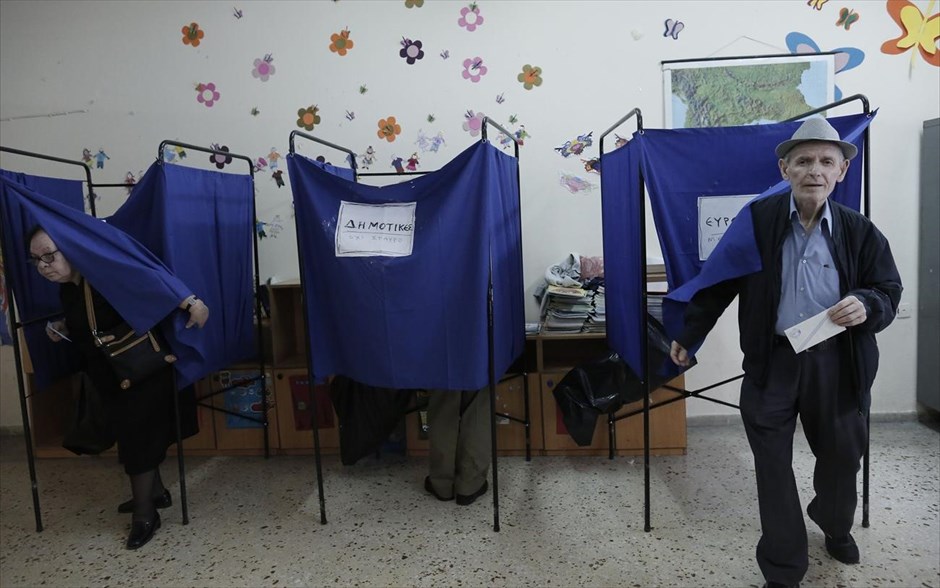 Αυτοδιοικητικές εκλογές - Ευρωεκλογές - Εκλογές. Πολίτες βγαίνουν από το παραβάν σε εκλογικό τμήμα.