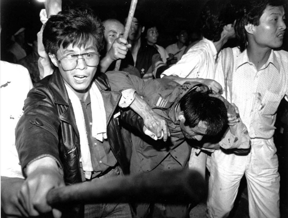 Κίνα - 1989: Η εξέγερση στην πλατεία Τιενανμέν. Φοιτητές προσπαθούν να μεταφέρουν έναν οδηγό τεθωρακισμένου οχήματος σε ασφαλές σημείο, καθώς το πλήθος τον χτυπά. Φωτογραφία αρχείου – 4 Ιουνίου 1989. Στις 3 και 4 Ιουνίου σηματοδοτείται η 25η επέτειος από την βίαιη καταστολή των διαδηλώσεων υπέρ της δημοκρατίας, στην πλατεία Τιενανμέν του Πεκίνου το 1989.