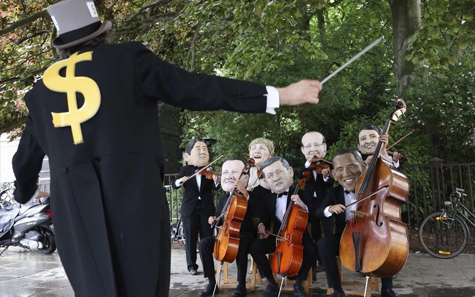 Διαμαρτυρία για τη Σύνοδο της G7 στις Βρυξέλλες. Ακτιβιστές, ντυμένοι ως μουσικοί και φορώντας μάσκες των μελών της ομάδας G7 διαμαρτύρονται κατά των οικονομικών ανισοτήτων έξω από το κτήριο του Ευρωπαϊκού Συμβουλίου στις Βρυξέλλες. Τα ισχυρότερα βιομηχανικά κράτη του πλανήτη συνεδριάζουν&nbsp; την Τετάρτη χωρίς τη Ρωσία, για πρώτη φορά μετά από 17 χρόνια, αφήνοντας τον Ρώσο πρόεδρο Βλαντιμίρ Πούτιν εκτός συνομιλιών, σε αντίποινα για την προσάρτηση της Κριμαίας.