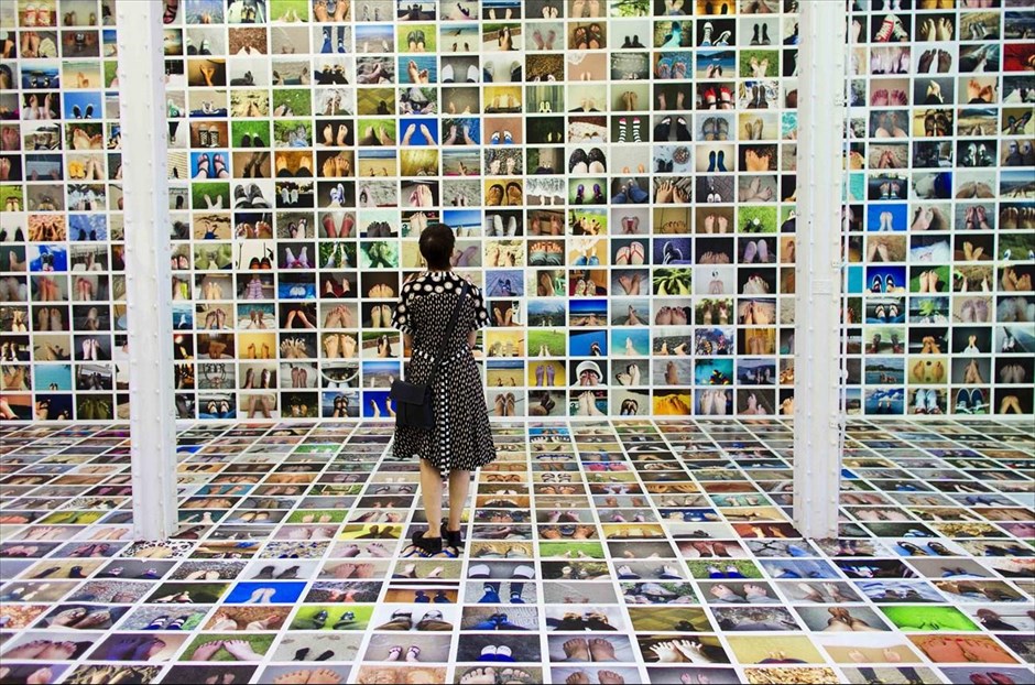 Κολάζ από «selfies» ποδιών. Μια γυναίκα κοιτά την εικαστική εγκατάσταση με τίτλο «Τα πόδια μου» του Erik Kessels σε φεστιβάλ φωτογραφίας στη Λειψία. Το έργο είναι κολάζ χιλιάδων «selfies» ποδιών.&nbsp;