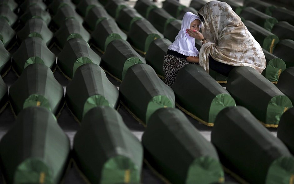 Βοσνία: 19η επέτειος της σφαγής στη Σρεμπρένιτσα. Μια γυναίκα και ένα παιδί κλαίνε πάνω από φέρετρα θυμάτων της σφαγής στη Σρεμπρένιτσα, τα οποία ταυτοποιήθηκαν κατά την περασμένη επέτειο και πρόκειται να ταφούν μετά την θρησκευτική τελετή στο μνημείο που έχει ανεγερθεί για τα θύματα της σφαγής στο Ποτοτσάρι. Η σφαγή στη Σρεμπρένιτσα, που χαρακτηρίζεται γενοκτονία από τη διεθνή δικαιοσύνη, έλαβε χώρα τον Ιούλιο του 1995, μερικούς μήνες πριν από το τέλος του πολέμου της Βοσνίας (1992-1995). Οι σερβικές δυνάμεις της Βοσνίας σφαγίασαν περίπου 8.000 Βόσνιους μουσουλμάνους άνδρες και εφήβους, στη χειρότερη σφαγή που διαπράχθηκε στην Ευρώπη μετά τον Β