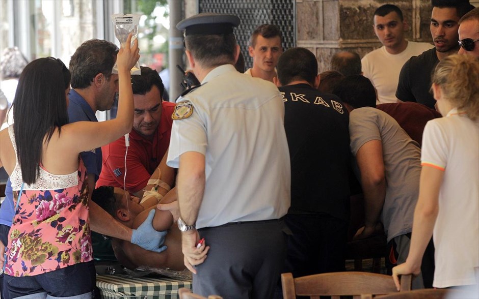 Σύλληψη του Ν. Μαζιώτη στο Μοναστηράκι. Άντρες του ΕΚΑΒ, αστυνομικοί και πολίτες δίνουν τις πρώτες βοήθειες σε τουρίστα που τραυματίστηκε κατά τη διάρκεια της ένοπλης συμπλοκής.