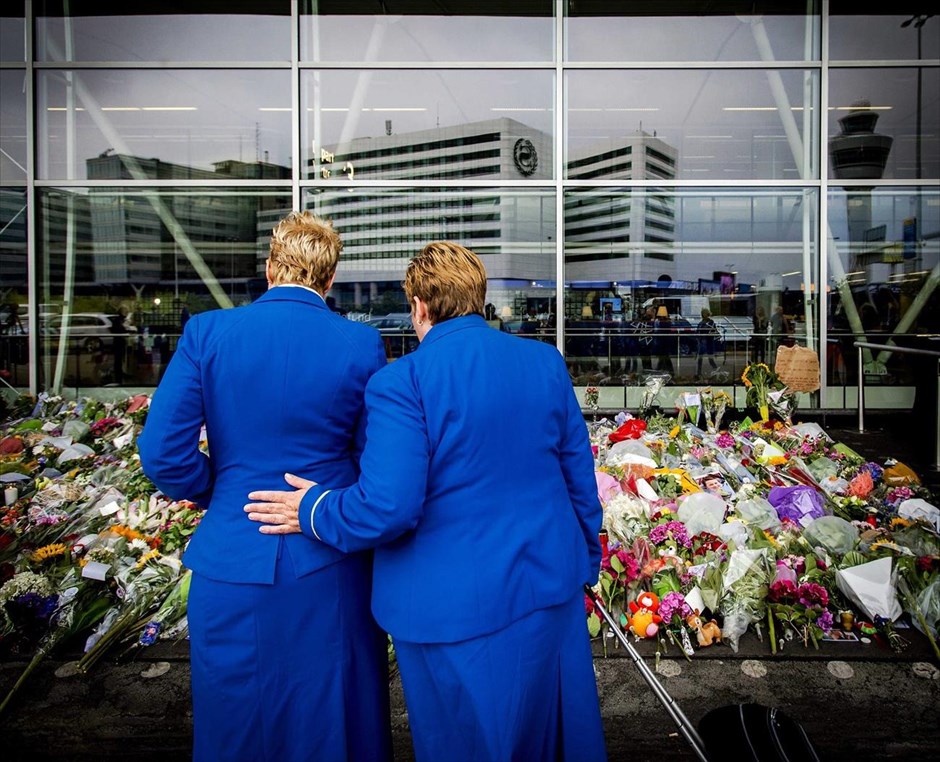 Ολλανδία: Τελετές μνήμης για τα θύματα του Boeing. Δύο αεροσυνοδοί κοιτούν τα λουλούδια που έχουν συγκεντρωθεί στο αεροδρόμιο Σκίπχολ του Άμστερνταμ, στη μνήμη των ανθρώπων που έχασαν τη ζωή τους από τη συντριβή του μαλαισιανού αεροσκάφους στην Ουκρανία,. Συνολικά 251 πτώματα και 86 ανθρώπινα μέλη είχαν ανασυρθεί μέχρι αργά το βράδυ της Κυριακής από τα συντρίμμια του αεροσκάφους της Malaysia Airlines, ενώ και δεύτερο τρένο με βαγόνια-ψυγεία έχει φθάσει στην περιοχή για τη μεταφορά τους.