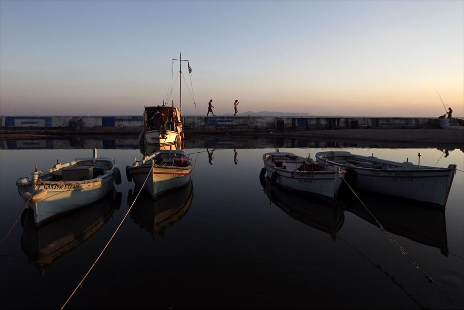 Βόλτα δίπλα στη θάλασσα. Κόσμος περπατά σε προβλήτα σε παραθαλάσσιο προάστιο της Αττικής.
