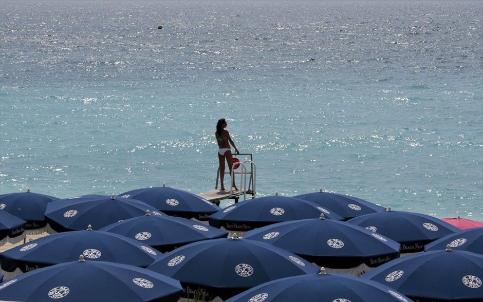 Γαλλία: Ηλιόλουστη καλοκαιρινή ημέρα στην παραλία. Μία γυναίκα ατενίζει τη θέα σε μία ιδιωτική παραλία στη Νίκαια, στη νοτιοανατολική Γαλλία.