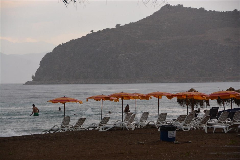 Μπάνιο στη θάλασσα υπό βροχή. Κάποιοι λουόμενοι αψήφησαν την καταιγίδα την Τετάρτη και απόλαυσαν το μπάνιο τους στη παραλία της Καραθώνας στο Ναύπλιο.