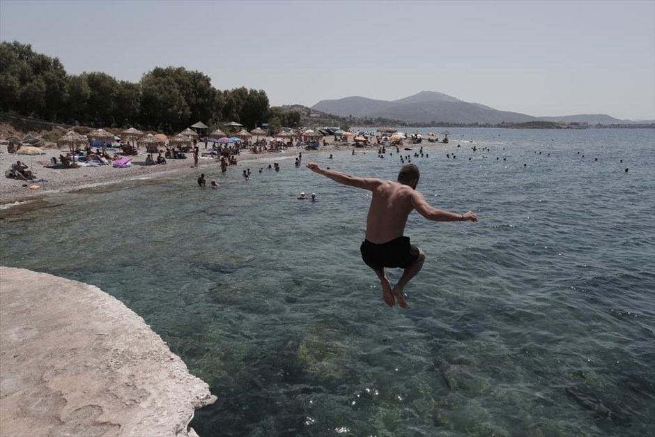 Βουτιές στο Λαγονήσι. Παραλία στο Λαγονήσι έχει κατακλυστεί από λουόμενους σε αναζήτηση δροσιάς, καθώς κύμα καύσωνα πλήττει την Αθήνα.