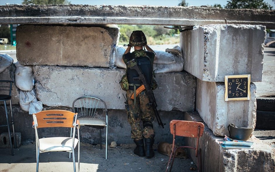 Αμείωτη η ένταση στην Ουκρανία. Ένας Ουκρανός στρατιώτης φρουρεί ένα σημείο ελέγχου κοντά στην πόλη της ανατολικής Ουκρανίας Debalcevo. Η κλιμάκωση της κρίσηςστην περιοχή προέκυψε την Παρασκευή όταν ο πρόεδρος της Ουκρανίας Πέτρο Ποροσένκο ανακοίνωσε ότι το πυροβολικό των ενόπλων δυνάμεων έπληξε&nbsp; μέρος των ρωσικών τεθωρακισμένων που πέρασαν τα σύνορα.