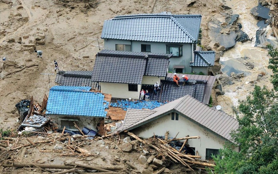 Κατολισθήσεις στη Χιροσίμα 2. Ντόπιοι κάτοικοι περιμένουν τα σωστικά συνεργεία στις οροφές των σπιτιών τους που κατέρρευσαν από τις κατολισθήσεις.