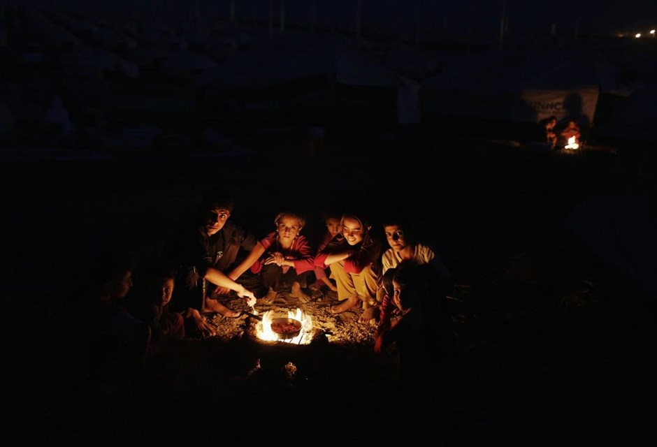 Στον προσφυγικό καταυλισμό της Ντουχόκ. Παιδιά της κουρδικής μειονότητας Γιαζίντι, περιμένουν το φαγητό τους δίπλα στη φωτιά που έχουν ανάψει, στον καταυλισμό προσφύγων Bajed Kadal, νοτιοδυτικά της επαρχίας Ντοχούκ&nbsp;στο βόρειο&nbsp;Ιράκ. Δεκάδες χιλιάδες μέλη της κουρδικής μειονότητας Γιαζίντι εγκατέλειψαν το προπύργιό τους το Σινζάρ, το οποίο κατέλαβε το Ισλαμικό Κράτος στις 3 Αυγούστου και κατέφυγαν στα γύρω βουνά ή στο Κουρδιστάν.