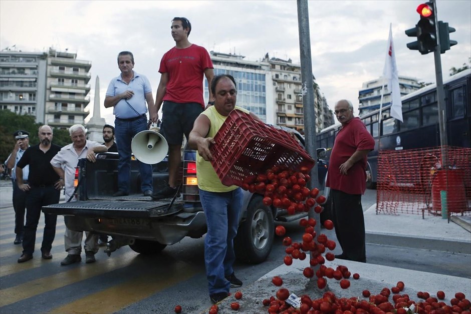 79η ΔΕΘ - Διαδηλώσεις. Αγρότες που συμμετέχουν στην πορεία του Πανεργατικού Αγωνιστικού Μετώπου αδειάζουν καφάσια με ντομάτες.