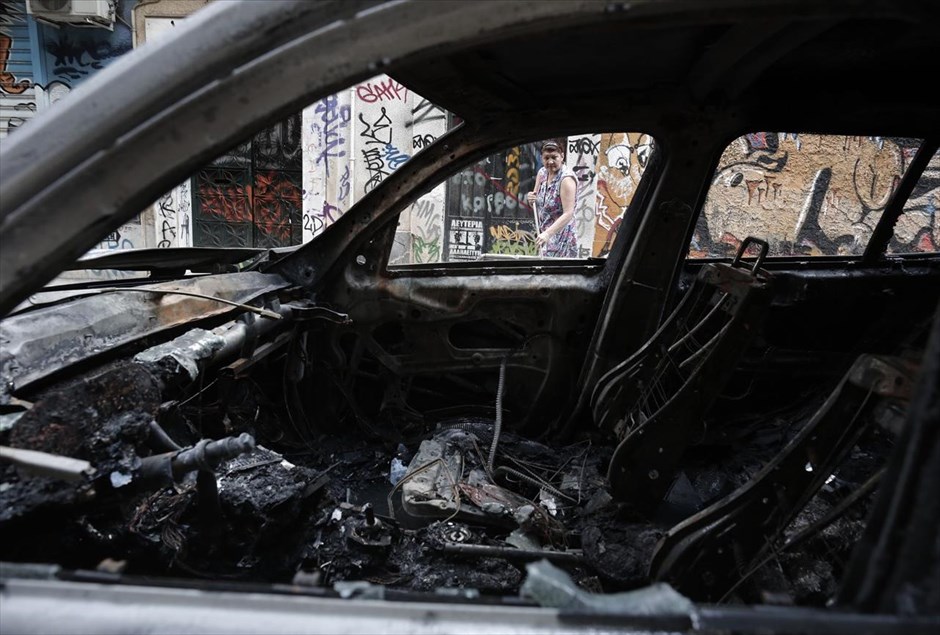 «Βροχή» από μολότοφ στα Εξάρχεια. Μία γυναίκα σκουπίζει το πεζοδρόμιο πίσω από ένα καμένο αυτοκίνητο στα Εξάρχεια. Επίθεση με βόμβες μολότοφ, εναντίον διμοιρίας των ΜΑΤ εξαπέλυσε λίγο πριν τα μεσάνυχτα του Σαββάτου ομάδα νεαρών στη συμβολή των οδών Ζωοδόχου Πηγής και Μεταξά. Ακολούθησε αστυνομική επιχείρηση στην περιοχή και προσήχθησαν 22 άτομα, από τα οποία δύο κρατήθηκαν και θα οδηγηθούν σήμερα στον εισαγγελέα, ενώ οι υπόλοιποι 20 αφέθηκαν ελεύθεροι.