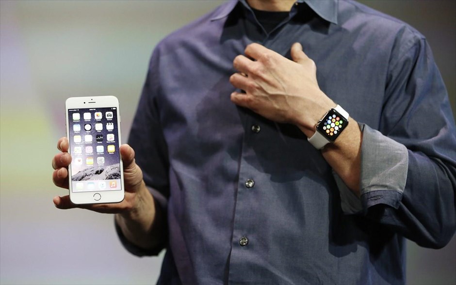 Η παρουσίαση του νέου iPhone 6 - Apple watch. O διευθύνων σύμβουλος της Apple, Tim Cook, κρατάει το iPhone 6 Plus και φοράει το Apple Watch.