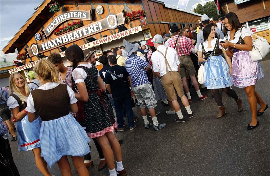 Γερμανία - Στο ρυθμό του Oktoberfest. Επισκέπτες του Oktoberfest φορώντας παραδοσιακές ενδυμασίες της Βαυαρίας, περιμένουν έξω από ένα κιόσκι μπύρας στο Μόναχο.