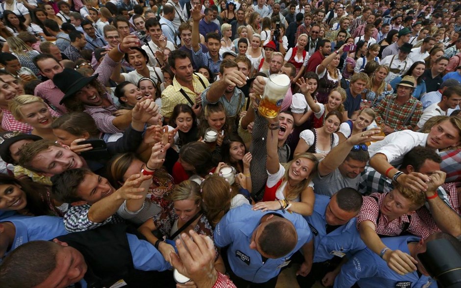 Γερμανία - Στο ρυθμό του Oktoberfest. Κόσμος κρατά το πρώτο ποτήρι μπύρας, μετά το άνοιγμα του πρώτου βαρελιού, κατά τη διάρκεια των εγκαινίων του 181ου Oktoberfest στο Μόναχο.