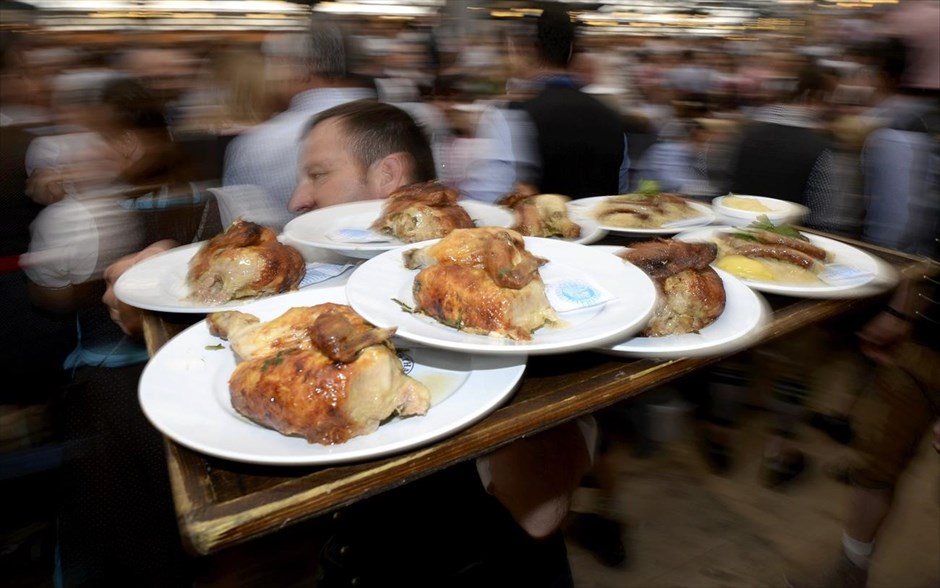 Γερμανία - Στο ρυθμό του Oktoberfest. Σερβιτόρος κουβαλά ένα δίσκο με ψητό κοτόπουλο, κατά την ημέρα των εγκαινίων του 181ου Oktoberfest στο Μόναχο.