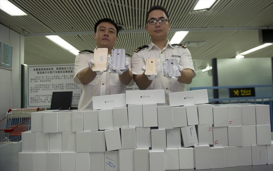 Λαθραία iPhone 6 κατασχέθηκαν στην Κίνα. Τελωνειακοί υπάλληλοι φωτογραφίζονται κρατώντας  λαθραία iPhone 6, τα οποία κατασχέθηκαν στο τελωνείο του λιμένα της Σενζέν, κοντά στα σύνορα με το Χονγκ Κονγκ, στην επαρχία Γκουανγκντόνγκ.