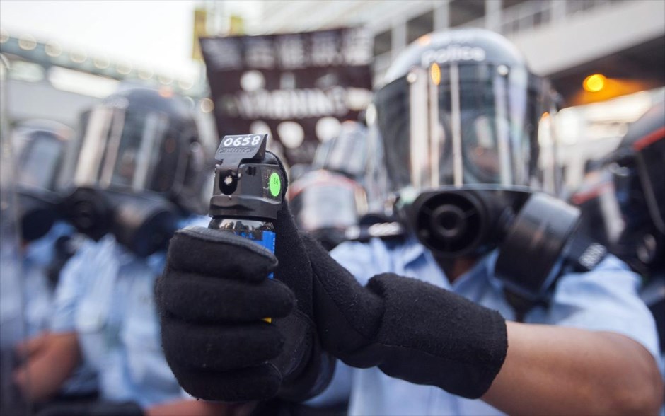 Φιλοδημοκρατικές κινητοποιήσεις στο Χονγκ Κονγκ. Αστυνομικός ετοιμάζεται να προχωρήσει σε ρίψη δακρυγόνων κατά των διαδηλωτών.&nbsp;