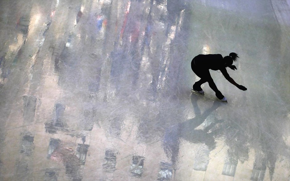 Αντανακλάσεις στον πάγο. Κοπέλα γλιστρά στο παγοδρόμιο του Ρόκφελερ Σέντερ στο Μανχάταν. Στον πάγο αντανακλώνται γειτονικά κτήρια.