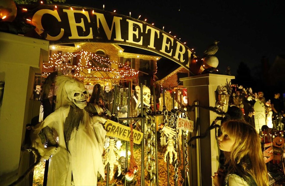 Halloween . Μία κοπέλα κοιτά ένα κήπο σπιτιού που είναι γεμάτος με διακοσμητικά για το Halloween, στο προάστιο του Σικάγου, Νάπερβιλ, στις ΗΠΑ. Οι διακοσμήσεις στο Νάπερβιλ είναι τόσο περίτεχνες φέτος, με αποτέλεσμα να οργανωθούν ξεναγήσεις στην περιοχή.