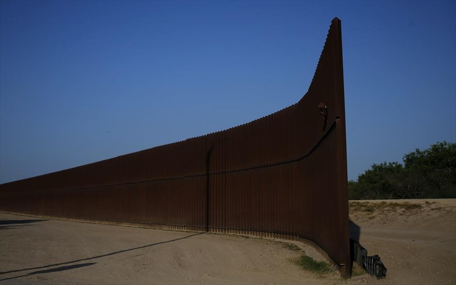 Τα τείχη που χωρίζουν τον κόσμο - ΗΠΑ - Μεξικό. Ο συνοριακός φράκτης στα σύνορα ΗΠΑ-Μεξικού, έξω από το Μπράουνσβιλ, στο Τέξας. Ο φράχτης μεταξύ ΗΠΑ και Μεξικού κατασκευάστηκε με σκοπό να αποτρέψει την παράνομη μετανάστευση και τη διακίνηση ναρκωτικών από το Μεξικό και την Κεντρική Αμερική προς τις ΗΠΑ. Πρόκειται για ένα μεταλλικό τείχος που καλύπτει το ένα τρίτο της συνοριακής γραμμής των δύο χωρών και ξεκίνησε να κατασκευάζεται από το 1991. Οι εργασίες σταμάτησαν το 2010 λόγω του αυξανόμενου κόστους. Τα 1.000 χιλιόμετρα που κατασκευάστηκαν μέχρι τότε κόστισαν περισσότερο από 3 δισ. δολάρια. Εχει ύψος 4-5 μέτρα και είναι εξοπλισμένο με κάμερες, ραντάρ και αισθητήρες υπέρυθρης ακτινοβολίας.