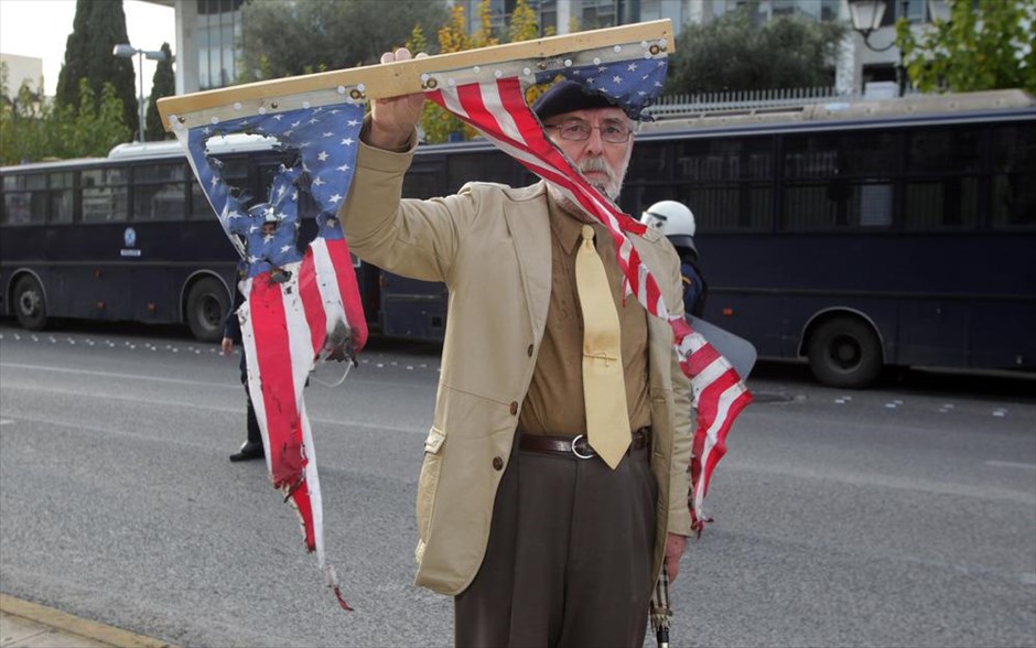 Πορεία για την 41η επέτειο της εξέγερσης του Πολυτεχνείου. Διαδηλωτής κρατά καμένη σημαία των ΗΠΑ έξω από την Αμερικανική Πρεσβεία, κατά τη διάρκεια πορείας φοιτητών για την 41η επέτειο της εξέγερσης του Πολυτεχνείου.