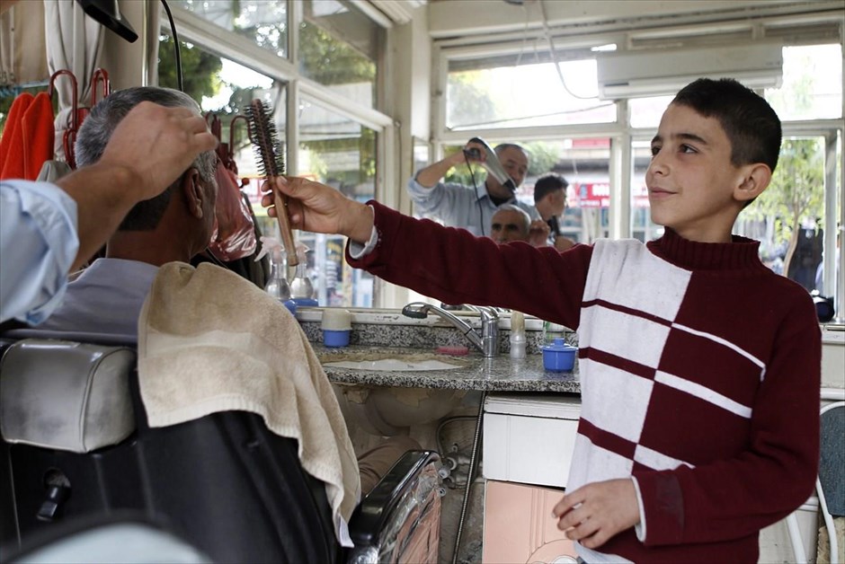 Μεγαλώνοντας απότομα. Ο δωδεκάχρονος Μουσταφά Αζίζ εργάζεται σε κουρείο στο Σουρούτς της τουρκικής επαρχίας Σανλιούρφα. Ο Μουσταφά κατέφυγε στην Τουρκία από το Κομπάνι με τους γονείς του και τα δέκα αδέρφια του. Εργάζεται 5 - 8 ώρες την ημέρα στο κουρείο και αμείβεται με περίπου 10 τουρκικές λίρες (3,5 ευρώ) την ημέρα. Ο πατέρας του είχε συνεργείο αυτοκινήτων στο Κομπάνι, το οποίο αναγκάστηκε να εγκαταλείψει μετά το ξέσπασμα των μαχών με τους τζιχαντιστές του Ισλαμικού Κράτους. Η οικογένεια του Μουσταφά ελπίζει ότι με την εξομάλυνση της κατάστασης θα μπορέσουν να επιστρέψουν στον τόπο τους και ο ίδιος στο σχολείο. 