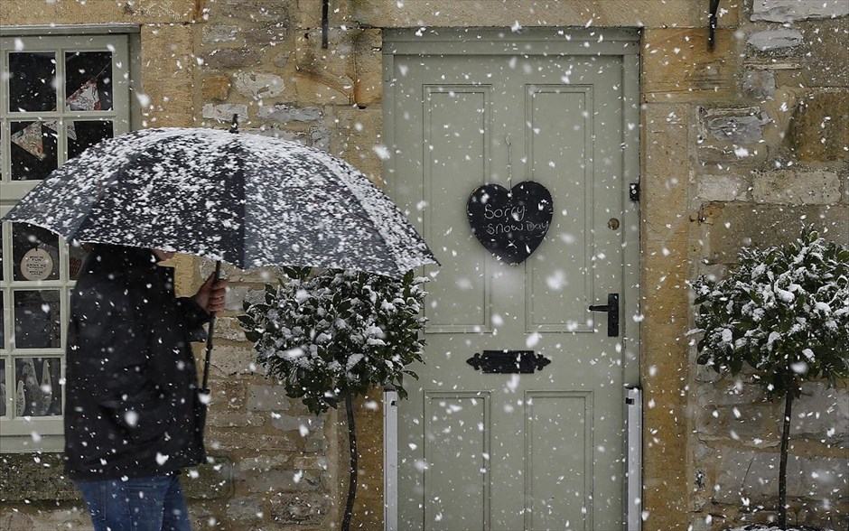 Χιόνι στη Βρετανία . Ένας άνδρας περνά μπροστά από ένα κλειστό λόγω της έντονης χιονόπτωσης μαγαζί, στο Άσφορντ της Βρετανίας.