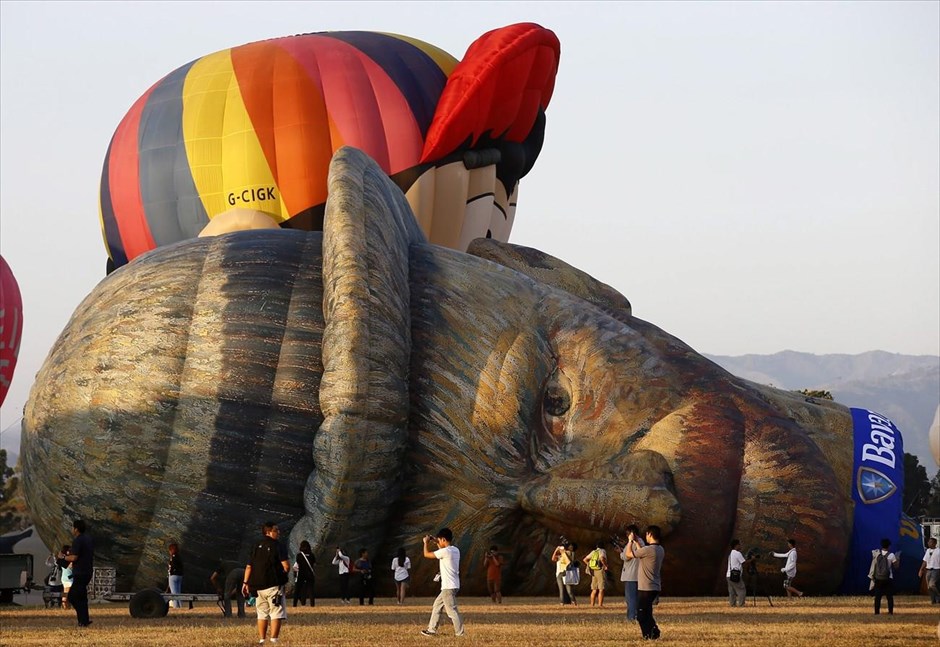 Υπό το βλέμμα του... Βαν Γκογκ. Αερόστατο με τη μορφή του ζωγράφου Βίνσεντ βαν Γκογκ βρίσκεται στο έδαφος, καθώς οι ειδικοί το προετοιμάζουν για την πτήση του στο πλαίσιο του 19ου φεστιβάλ αερόστατου που πραγματοποιείται στις Φιλιππίνες.