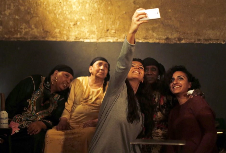 Η εποχή των «selfies». Μια παρέα γυναικών φωτογραφίζεται με τα μέλη του συγκροτήματος «Mazaher Zar», ύστερα από παραδοσιακό δρώμενο θεραπείας μέσω της μουσικής στο Κάιρο.&nbsp;