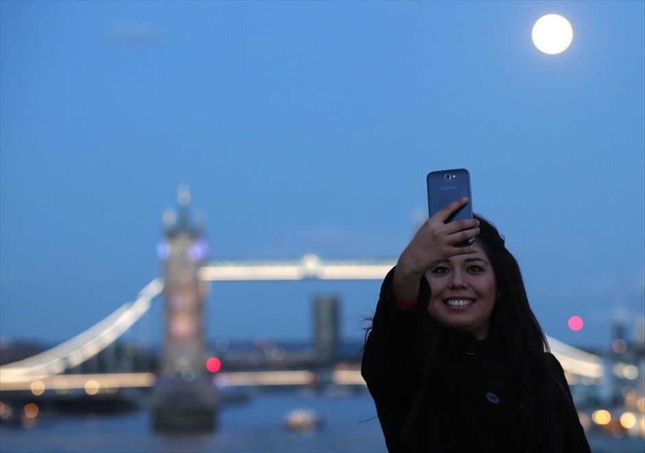 Η εποχή των «selfies». Μια γυναίκα φωτογραφίζεται με φόντο το φεγγάρι και τη γέφυρα του Λονδίνου.