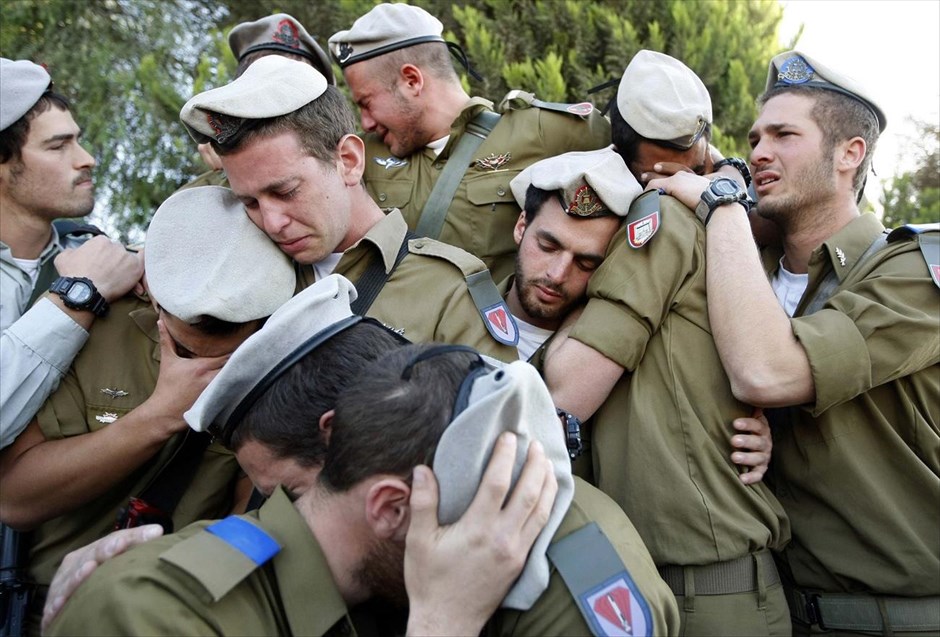 Αφιέρωμα - Reuters 30. Ισραηλινοί στρατιώτες θρηνούν κατά τη διάρκεια της κηδείας του συντρόφου τους Alex Mashavisky, σε ένα νεκροταφείο στην Μπιρσίμπα, 7 Ιανουαρίου 2009.Ο φωτογράφος Eric Gaillard περιγράφει: «Βρισκόμουν στο Ισραήλ για να βοηθήσω στο γραφείο του Reuters στην Ιερουσαλήμ, την περίοδο της επίθεσης στη Λωρίδα της Γάζας, τον Ιανουάριο του 2009. Μου ζήτησαν να μεταβώ στην Μπιρσίμπα να καλύψω την κηδεία ενός Ισραηλινού στρατιώτη, του Alex Mashavisky, ο οποίος σκοτώθηκε σε μία επιχείρηση στη Γάζα».«Κατά τη διάρκεια της κηδείας υπήρχε μεγάλη συγκίνηση, ενώ μέσα σε λίγα λεπτά, μία ρουκέτα εξερράγη κοντά στο νεκροταφείο και όλοι έπρεπε να πέσουν στο έδαφος για κάλυψη. Ήταν ταυτόχρονα μία σουρεαλιστική και πραγματικά πολύ συναισθηματικά φορτισμένη σκηνή. Το μέρος ήταν πολύ στενάχωρο και υπήρχαν υπερβολικά πολλοί φωτογράφοι. Ήταν πρόκληση να βρεθεί ένα σημείο όπου θα μπορούσα να παρακολουθώ την τελετή και να τραβάω φωτογραφίες».