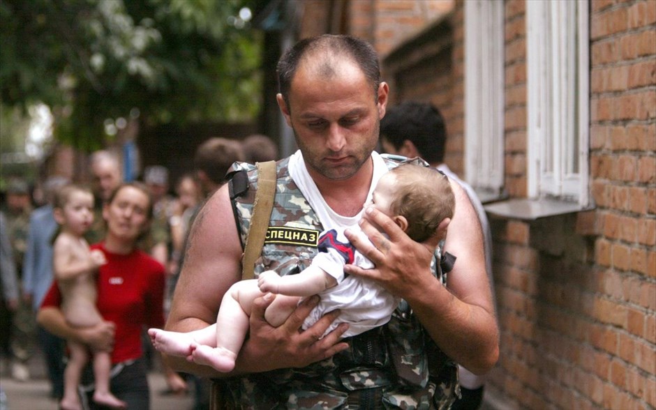 Αφιέρωμα – Reuters 30. Ρώσος αστυνομικός μεταφέρει στα χέρια του ένα μωρό που απελευθερώθηκε από τους βαριά οπλισμένους μασκοφόρους που είχαν καταλάβει ένα σχολείο στην πόλη Μπεσλάν, στην επαρχία της Βόρειας Οσετίας κοντά στην Τσετσενία στις 2 Σεπτεμβρίου 2004.Ο Viktor Korotayev αφηγείται: «Η ομηρία στο σχολείο του Μπεσλάν πραγματοποιήθηκε την 1η Σεπτεμβρίου του 2004, κατά τη διάρκεια μιας εορταστικής τελετής για την έναρξη του νέου ακαδημαϊκού έτους στο σχολείο Νο.1. Ομάδα ένοπλων Τσετσένων και Οσέτιων ανταρτών κατέλαβαν το σχολείο και κράτησαν 1.300 ομήρους την πρώτη ημέρα. 331 άνθρωποι σκοτώθηκαν, οι μισοί από τους οποίους ήταν παιδιά».«Τη δεύτερη ημέρα της ομηρίας οι απαγωγείς πείστηκαν να αφήσουν ελεύθερες πολλές γυναίκες με μωρά, έτσι όταν ένας άνδρας της ειδικής μονάδας φάνηκε να βγαίνει από το κτήριο με ένα παιδί στα χέρια του, υπήρχε η ελπίδα ότι τα παιδιά θα μπορούσαν να σωθούν. Νομίζω ότι αυτός ήταν ο λόγος που η εν λόγω φωτογραφία δημοσιεύτηκε στις πρώτες σελίδες πολλών εφημερίδων και περιοδικών σε όλο τον κόσμο. Στην καριέρα μου, έχω καλύψει πολλά απαιτητικά θέματα, όπως στρατιωτικές συγκρούσεις σε διάφορες χώρες, καταστροφές και καταστάσεις ομηρίας. Η τραγωδία του Μπεσλάν παραμένει το μεγαλύτερο ψυχολογικό τραύμα που έχω βιώσει».