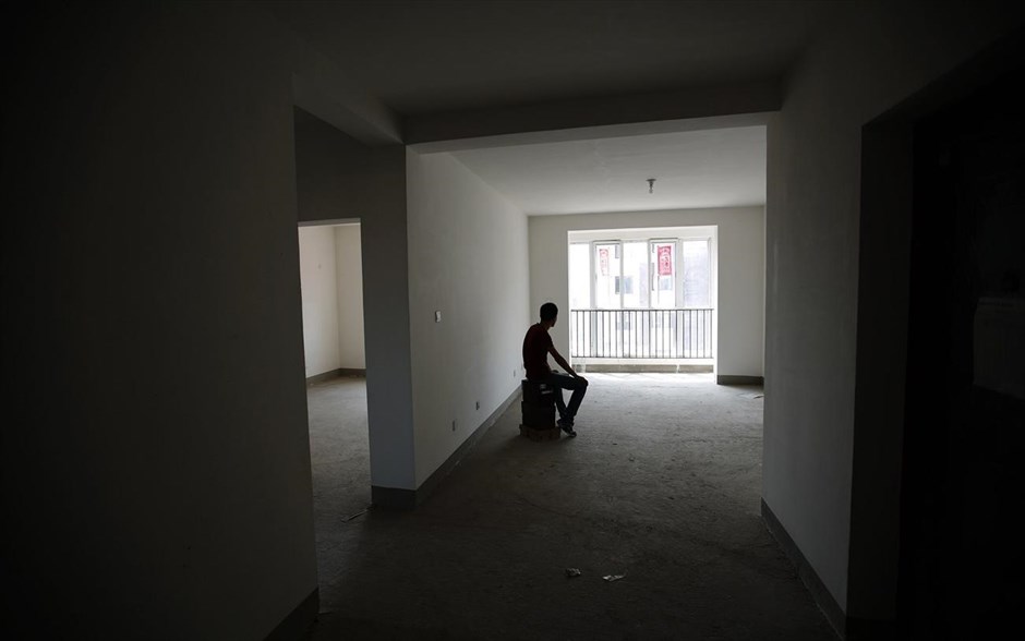 Μαλαισία: Ένας χρόνος από την εξαφάνιση της πτήσης MH370. Ο Ζιλιάνγκ, του οποίου η αρραβωνιαστικιά επέβαινε στην πτήση MH370, κάθεται σε ένα άδειο σπίτι, το οποίο σχεδίαζε να φτιάξει μαζί της για το γάμο τους, στο Τιαντζίν (φωτογραφία αρχείου, 26 Αυγούστου 2014).
