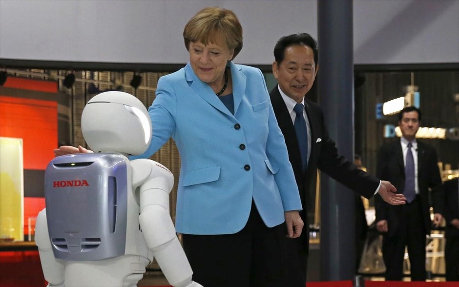 Η Άνγκελα Μέρκελ συναντά τον «Asimo». Η Γερμανίδα Καγκελάριος Άνγκελα Μέρκελ κατά την επίσκεψή της στο μουσείο αναδυόμενων επιστημών και καινοτομιών (Miraikan) του Τόκιο αγγίζει τον «Asimo», ένα ανθρωποειδές ρομπότ, δημιούργημα της Honda Motor Co.&nbsp;