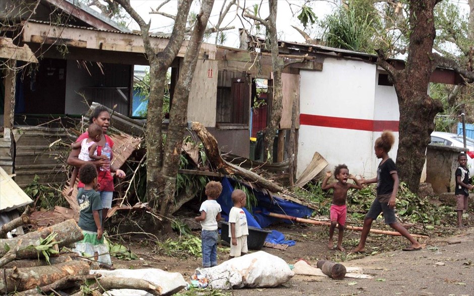 Ο κυκλώνας Παμ ισοπέδωσε το Βανουάτου. Μια γυναίκα στέκεται μαζί με τα πέντε παιδιά της και κοιτά τα απομεινάρια του σπιτιού της. Οι περισσότεροι κάτοικοι της περιοχής εγκατέλειψαν τα σπίτια τους καθώς το 90% των σπιτιών στην πρωτεύουσα Πορτ Βίλα έχουν ισοπεδωθεί ή υποστεί σοβαρές ζημιές.