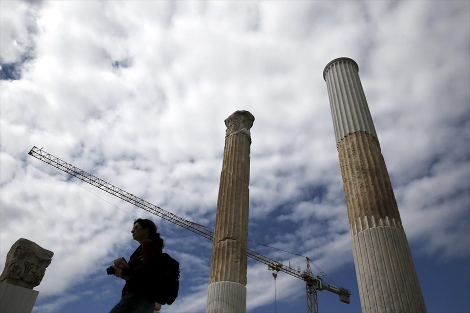 Βόλτα στο κέντρο της Αθήνας. Τουρίστρια περπατά δίπλα σε κίονες της βιβλιοθήκης του Αδριανού, στο κέντρο της Αθήνας.