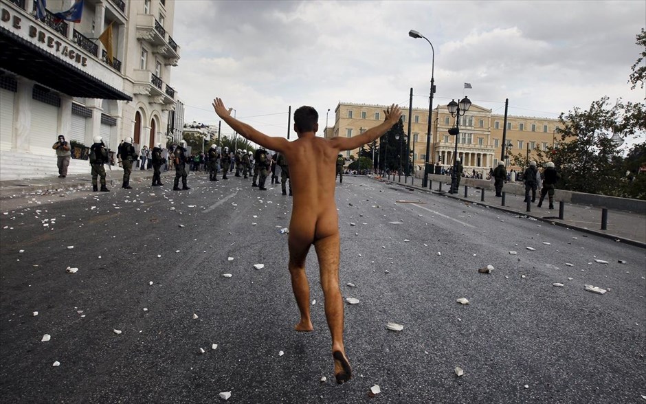 Ένας εναντίον πολλών. Διαδηλωτής τρέχει γυμνός στο Σύνταγμα κατά τη διάρκεια διαδηλώσεων με αφορμή την επίσκεψη της Γερμανίδας Καγκελαρίου Άνγκελα Μέρκελ στην Αθήνα, τον Οκτώβριο του 2012.
