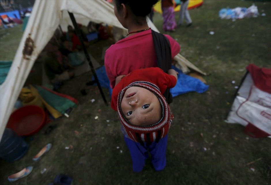 Στα 8 εκατομμύρια οι πληγέντες από τον σεισμό του Νεπάλ. Μια γυναίκα μεταφέρει στην πλάτη της το παιδί της, έξω από το αυτοσχέδιο κατάλυμα στο οποίο ζει πια η οικογένειά της στο Κατμαντού. Συνολικά 8 εκατομμύρια άνθρωποι έχουν πληγεί από τον σεισμό στο Νεπάλ, ενώ περισσότεροι από 1,4 εκατομμύριο έχουν επείγουσα ανάγκη για τρόφιμα, πόσιμο νερό και στέγη, σύμφωνα με τον Οργανισμό Ηνωμένων Εθνών (ΟΗΕ). Οι νεκροί σύμφωνα με τον νεότερο απολογισμό που ανακοίνωσε το υπουργείο Εωστερικών της χώρας έφτασαν 4.310. Οι τραυματίες που έχουν καταμετρηθεί μέχρι στιγμής είναι 7.953.